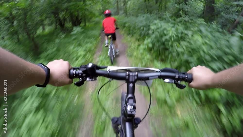 Father and son take part in a bicycle race in the forest Father and son take part in a bicycle race in the forest