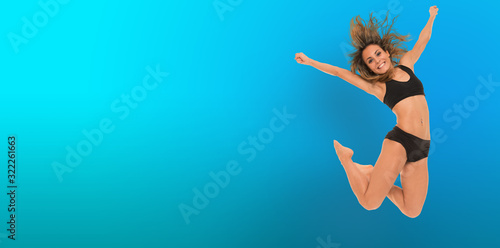 Young woman jumping  blue