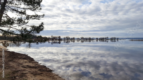 Biscarrosse sandy beach water reflection sky cloud in mirror image in lake landes France