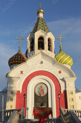 Russian tourist girl in vintage Pavlovo Posad shawl, look. Orthodox Saint Igor Chernigovsky's church in Novo-Peredelkino, Moscow city, Russia. Russian traditional national folk, retro style in fashion photo