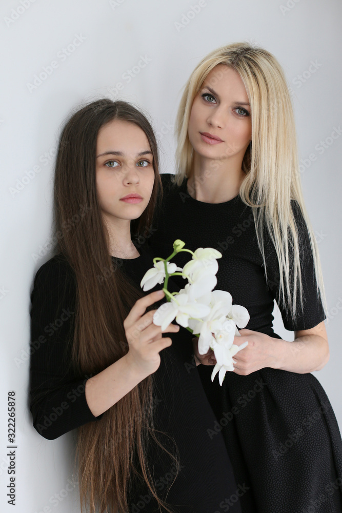 vertical photo in the studio of a European mother and daughter in black dresses vertical photo in the studio of a European mother and daughter in black dresses