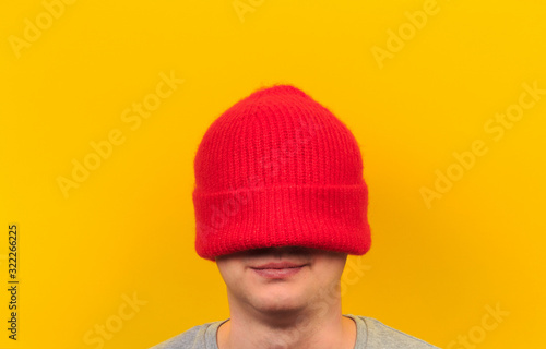 head of a man wearing colorful beanie hat on yellow background  - Image © Fototocam