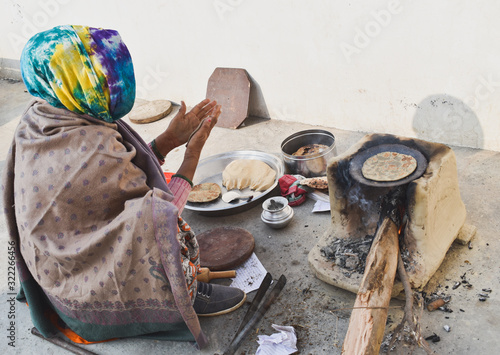 Indian village woman cooking food in traditional way 