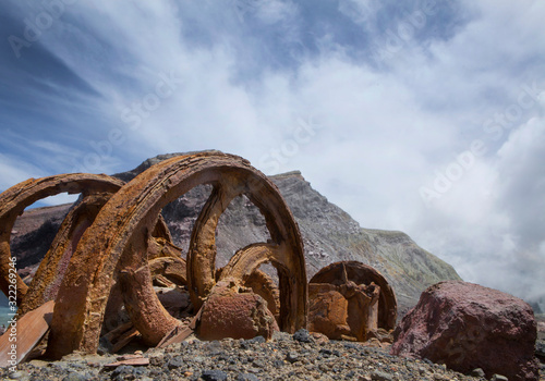 Whakaari White Island. Volcano. New Zealand. Taupo Volcanic Zone. Remnants of Sulpher mining. Abandoned rusty wheels photo