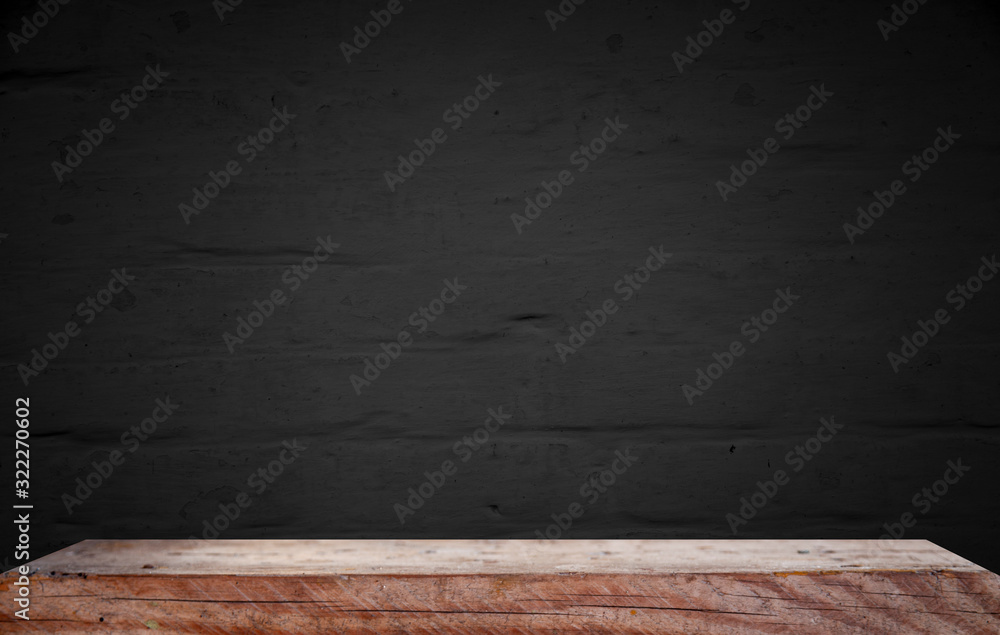 Empty wooden table on a background of dark blurred wall, empty space for product above Empty wooden table on a background of dark blurred wall, empty space for product above