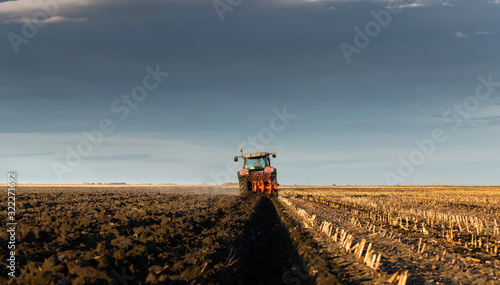 Tractor plowing fields in sunset