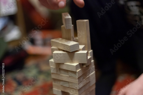 Tower of wooden blocks. Who will win and not drop more than one detail. A game for a fun company. The development of accuracy and fine motor skills. Wooden set of identical boards.
