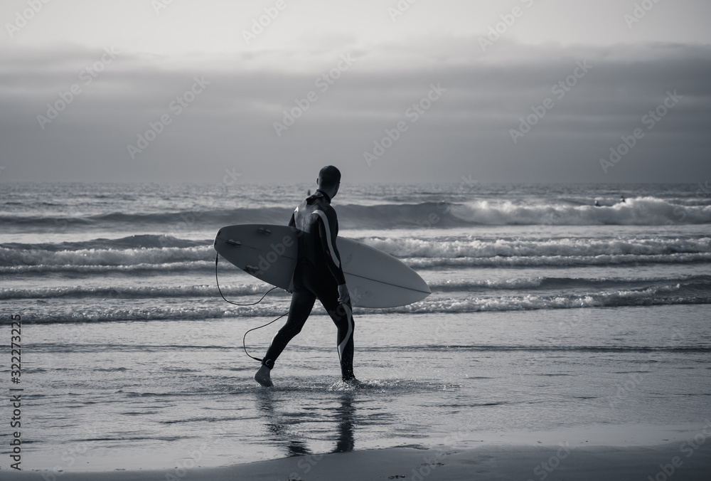 Strong surfer man with surfboard surfing at sunset or sunrise. Strong surfer man with surfboard surfing at sunset or sunrise.