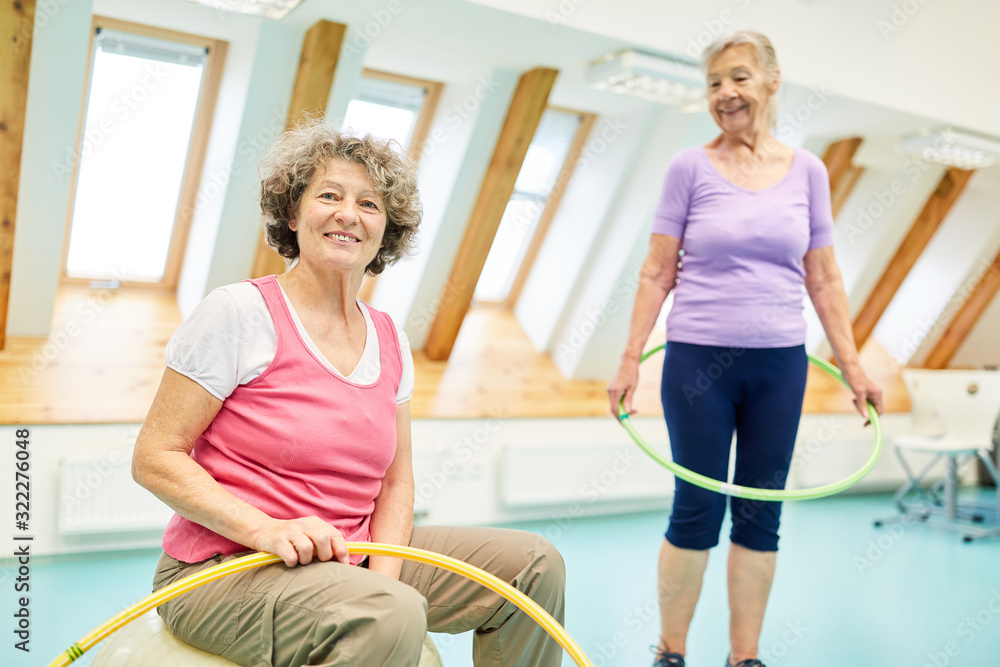 Two senior women are doing gymnastics with hoops