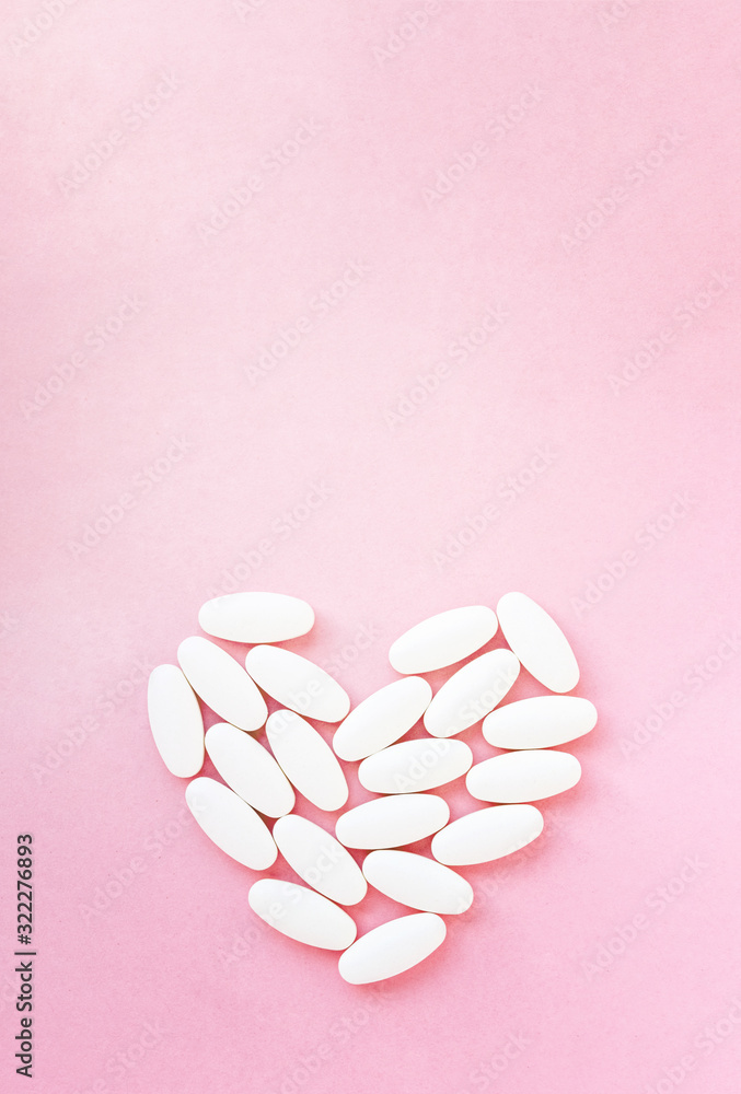 Heart shape made from pills for therapy, concept of treatment and health care on pink Heart shape made from pills for therapy, concept of treatment and health care on pink