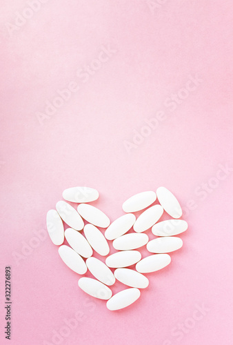 Heart shape made from pills for therapy  concept of treatment and health care on pink