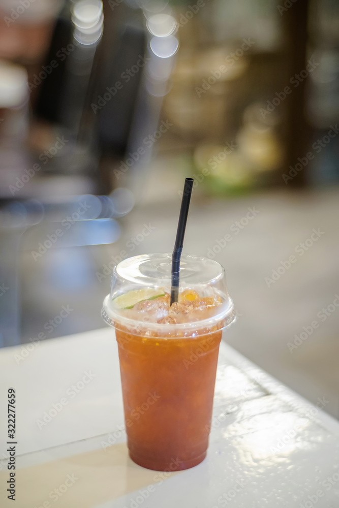 Ice tea with plastic glass on white table Ice tea with plastic glass on white table