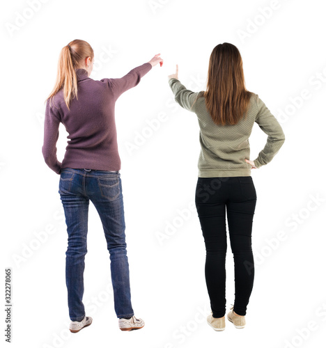 Back view of two pointing young girl in sweater.