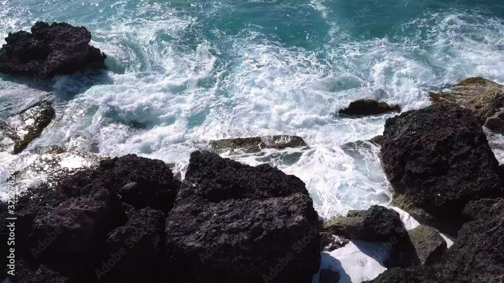 Rough waves crashing the rock shore of slugs bay in Malta, low drone flyover Rough waves crashing the rock shore of slugs bay in Malta, low drone flyover