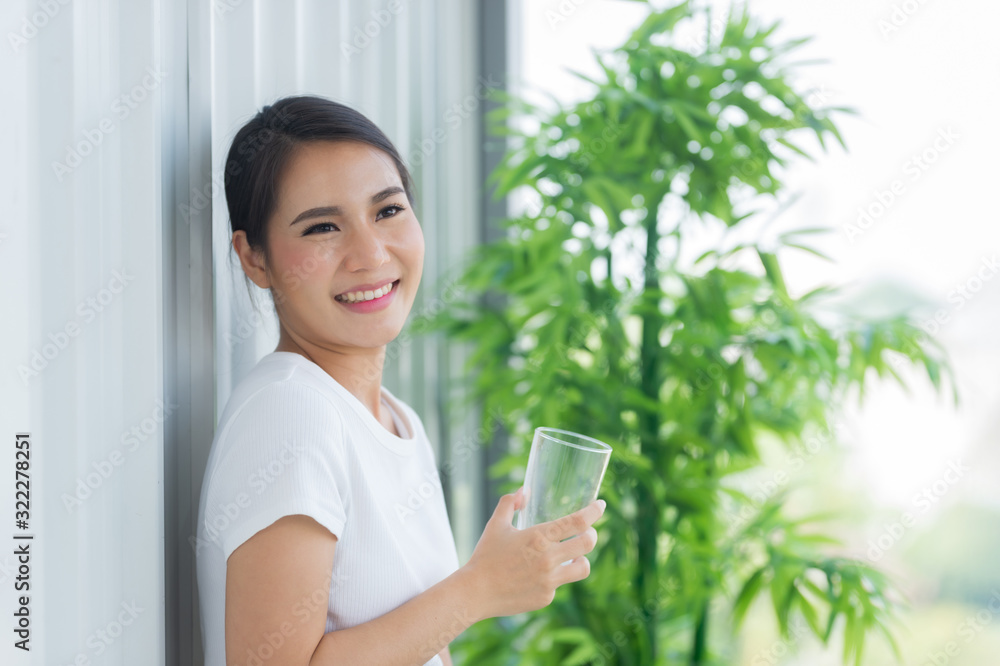 The healthy woman holding the glass of water and smiling The healthy woman holding the glass of water and smiling
