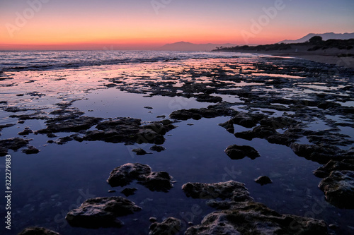 Beach rocks in low tide at the sunset in Marbella Cabopino beach © Antonio