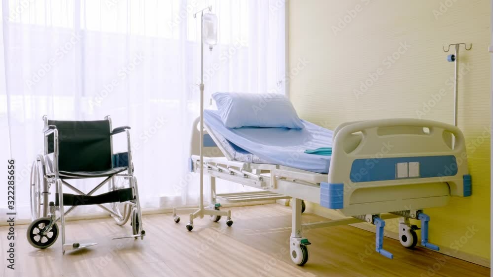 Bedroom for patient in a hospital, Empty bed and wheelchair on hospital ward Bedroom for patient in a hospital, Empty bed and wheelchair on hospital ward