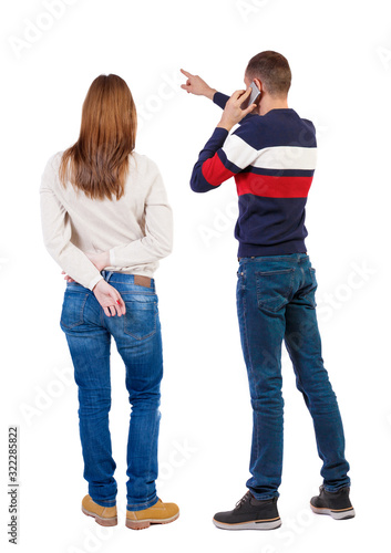 Back view of couple in sweater with mobile phone.
