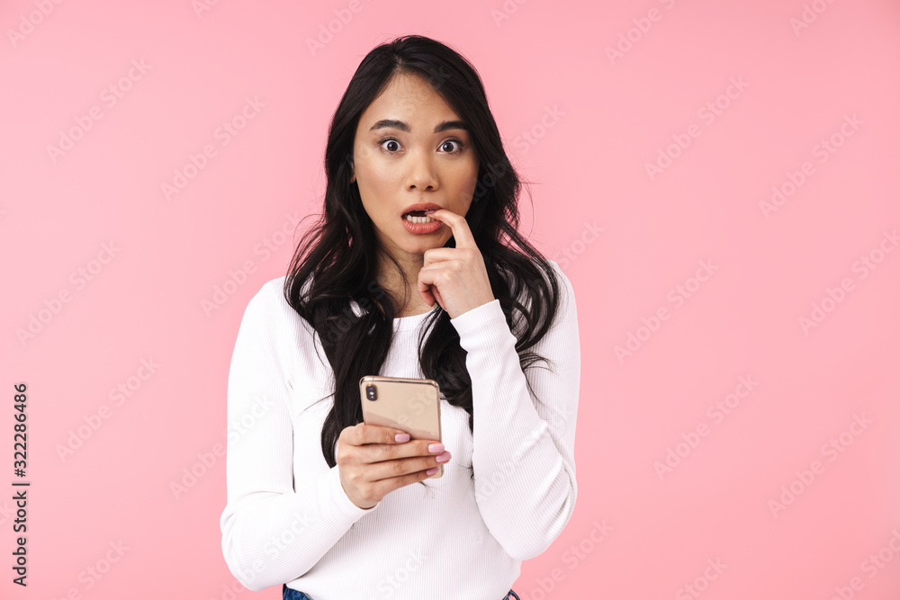 Image of young brunette asian woman with long hair holding cellphone Image of young brunette asian woman with long hair holding cellphone