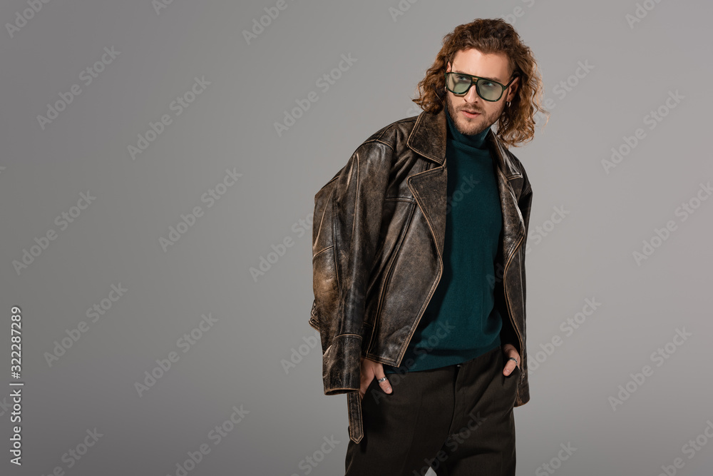 handsome man in leather jacket looking away isolated on grey handsome man in leather jacket looking away isolated on grey