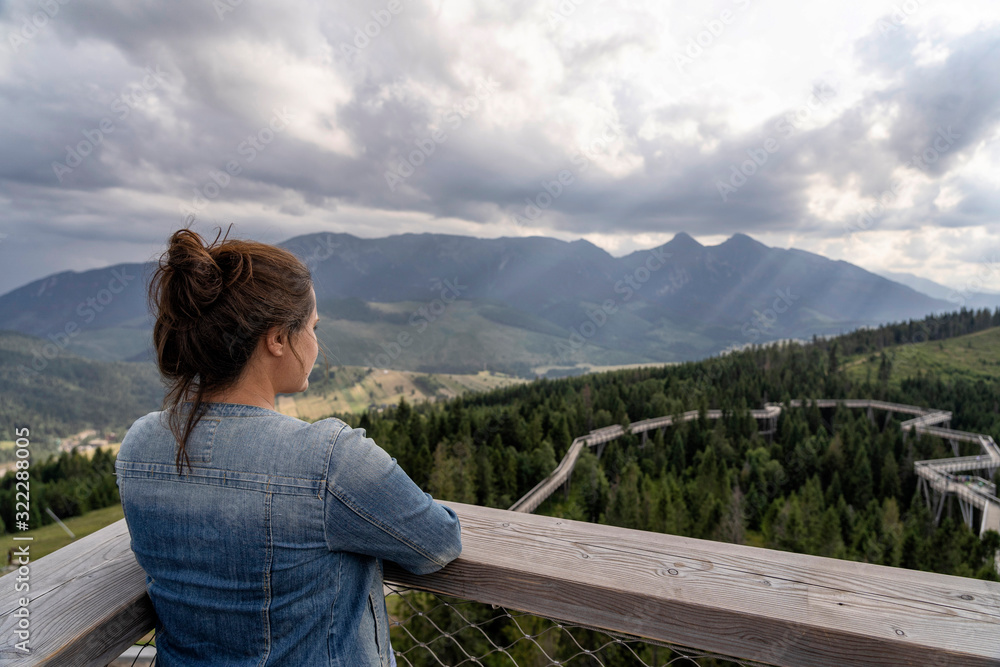 Young woman enjoying view of dramatic mountains. Selective focus. High Tatras, Slovakia.