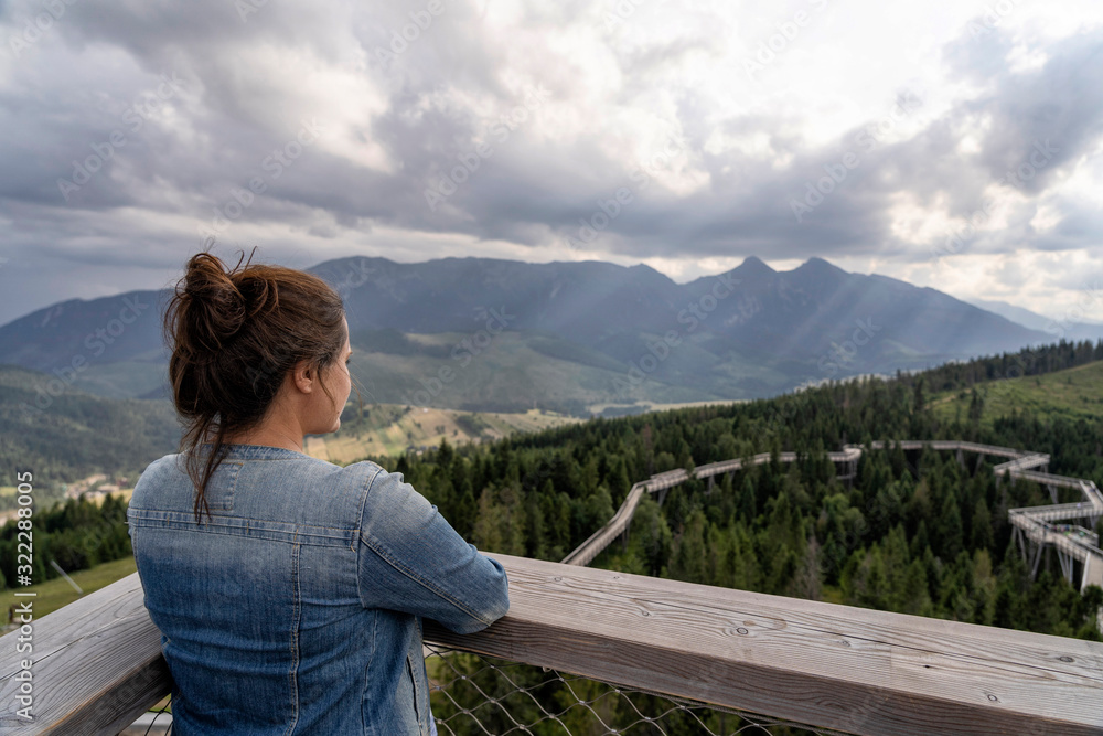 Young woman enjoying view of dramatic mountains. Selective focus. High Tatras, Slovakia. Young woman enjoying view of dramatic mountains. Selective focus. High Tatras, Slovakia.
