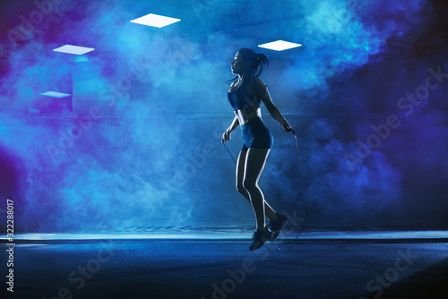 Athletic woman using skipping rope.