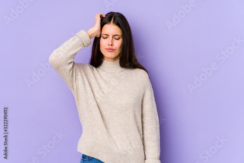 Young caucasian woman isolated on purple background tired and very sleepy keeping hand on head. © Asier