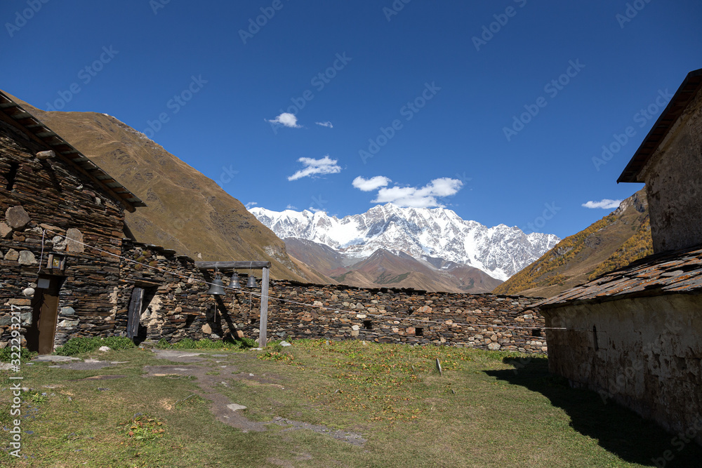 Old stone houses and fences of the village of Ushguli in a beautiful autumn landscape with white clouds in Svaneti. Georgia Old stone houses and fences of the village of Ushguli in a beautiful autumn landscape with white clouds in Svaneti. Georgia