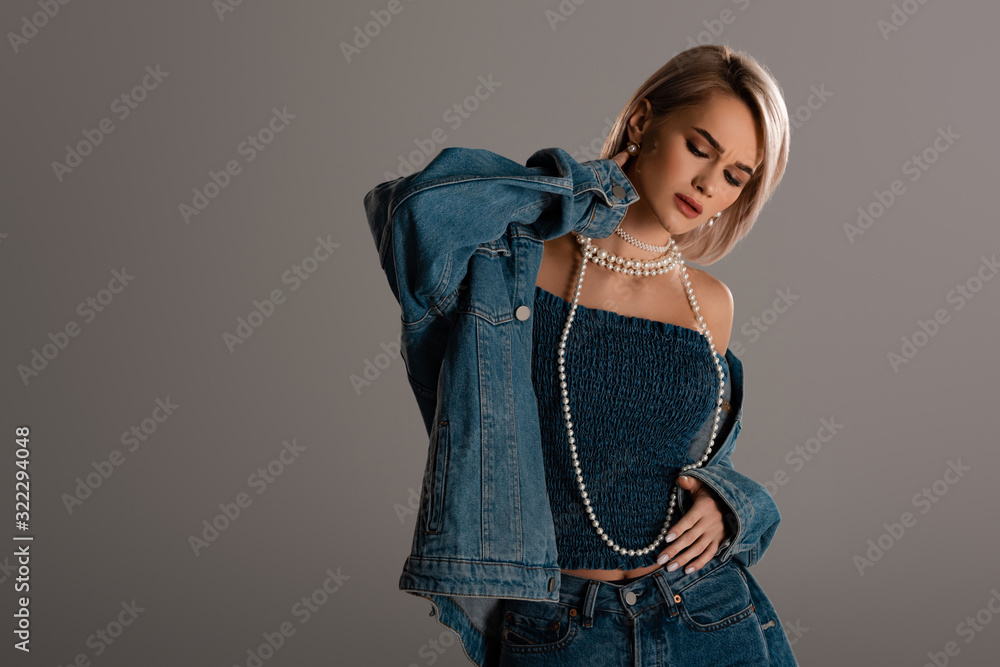attractive woman in denim jacket with closed eyes isolated on grey