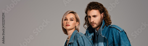 panoramic shot of stylish man and woman in denim jackets isolated on grey
