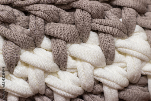 Seamless knitted background. Knitted texture from knitted thread. Texture of a carpet or basket. Handmade.