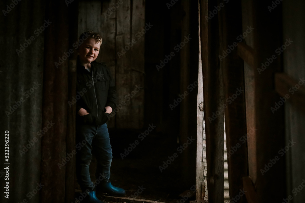 Young boy in dark hallway with dim light on face Young boy in dark hallway with dim light on face