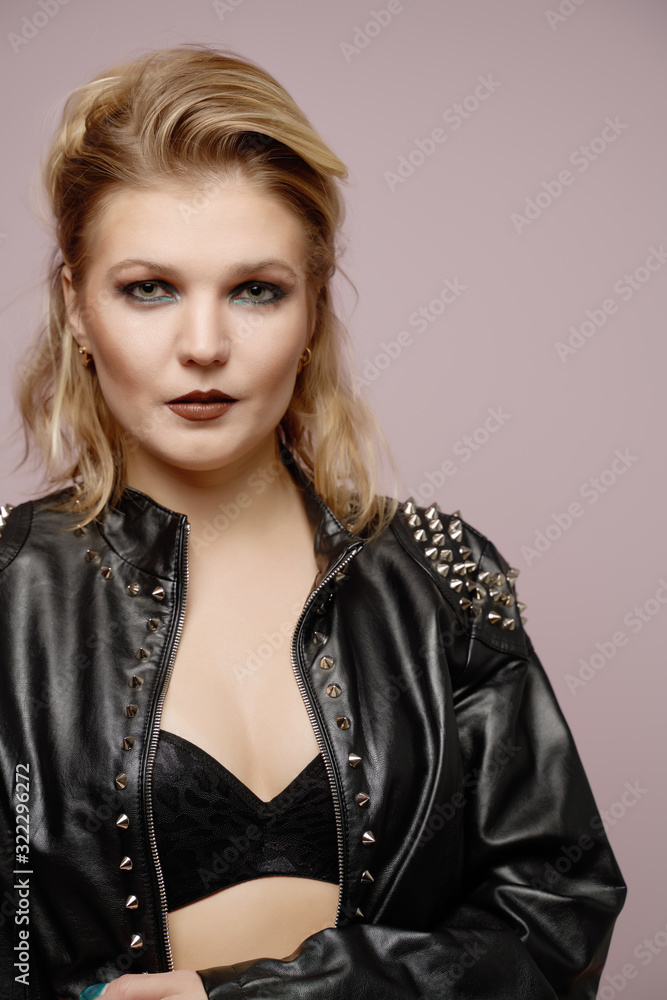 Fototapeta premium Woman blonde in leather jacket looking at camera isolated in studio