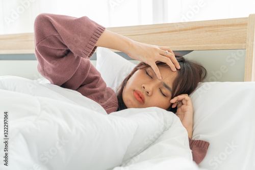 Asian women headache and sleeping on bed