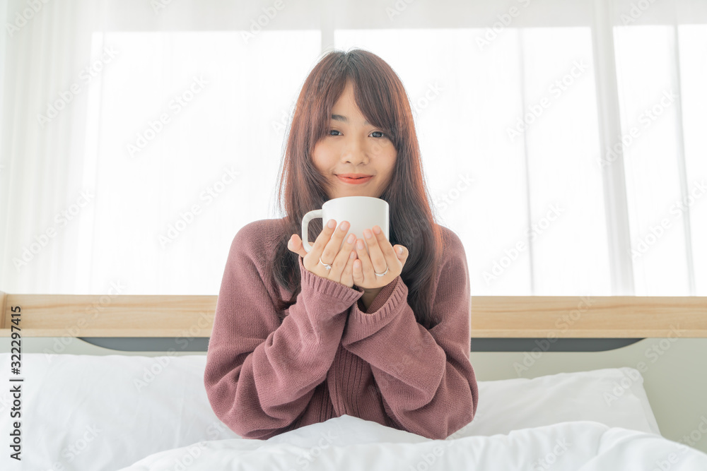 Asian women drinking coffee on bed in the morning Asian women drinking coffee on bed in the morning