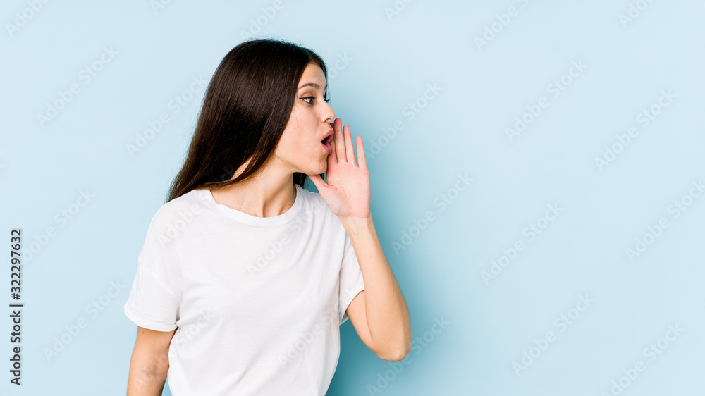 Young caucasian woman isolated on blue background is saying a secret hot braking news and looking aside Young caucasian woman isolated on blue background is saying a secret hot braking news and looking aside