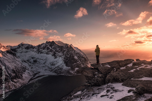 Man traveler standing on top of Ryten mount in sunset