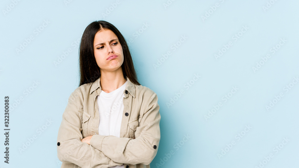 Young caucasian woman isolated on blue background tired of a repetitive task. Young caucasian woman isolated on blue background tired of a repetitive task.