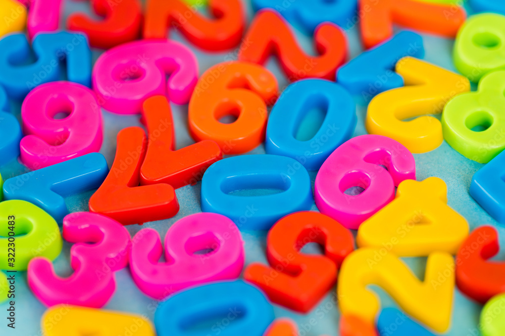 Selective focus of colorful plastic numbers on blue surface Selective focus of colorful plastic numbers on blue surface