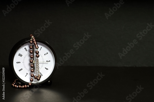 Alarm clock and tasbih or tasbeeh with black background photo