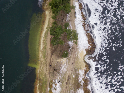 Aerial drone view. A frozen lake next to an unfrozen lake in a park.