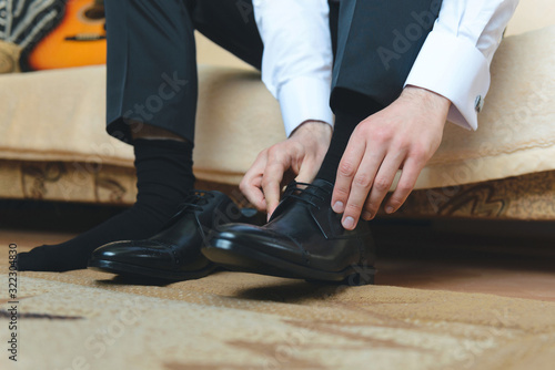 groom putting on black shoes