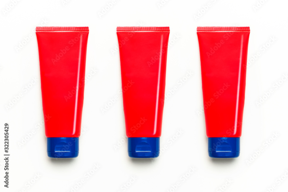 Red clean empty tube of cream or gel for hands, face, body on white background. Flat lay top view copy space. Mock-up of cosmetics spa cream bottles container. Template for design and logo application Red clean empty tube of cream or gel for hands, face, body on white background. Flat lay top view copy space. Mock-up of cosmetics spa cream bottles container. Template for design and logo application
