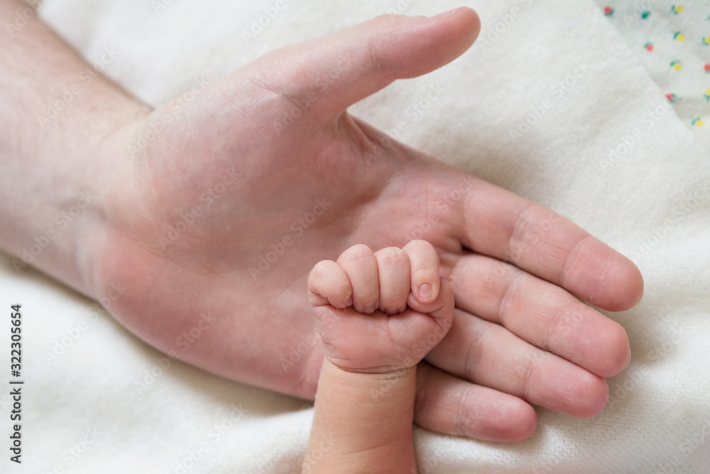 Small hand of a newborn baby on the background of the big palm of his father Small hand of a newborn baby on the background of the big palm of his father
