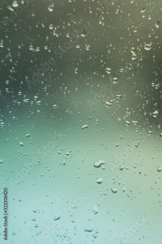 Rain drops fall on window. Wet rainy weather. Water drops strike