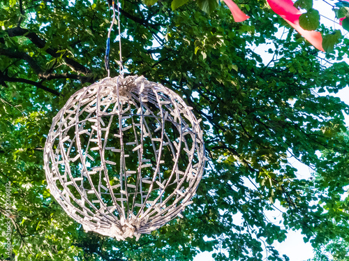 Large, shiny balls on the branches of a tree. Street decorations. Closeup. Festive garlands on the tree create a festive and magical atmosphere. photo