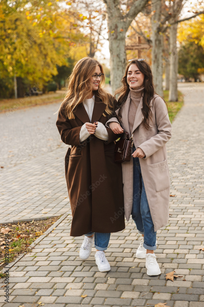 Naklejka premium Cheery optimistic young women friends walking