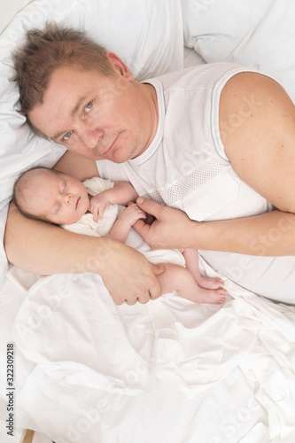 dad with a newborn baby resting