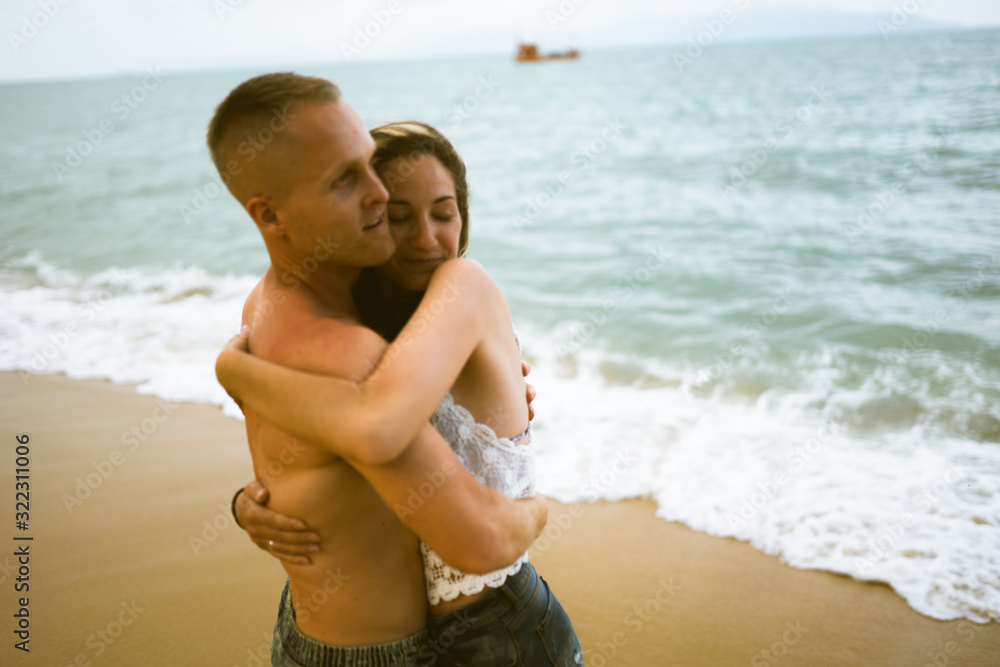 Beautiful guy and girl run and enjoy on the beach on the ocean or sea. Honeymoon in the tropics of a husband and wife. Romance in hot countries. Wallow in the sand and be happy and in love. Lovers Beautiful guy and girl run and enjoy on the beach on the ocean or sea. Honeymoon in the tropics of a husband and wife. Romance in hot countries. Wallow in the sand and be happy and in love. Lovers